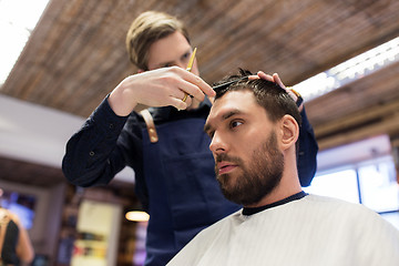 Image showing man and barber cutting hair at barbershop