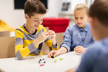 Image showing happy children building robots at robotics school