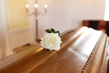 Image showing white rose flower on wooden coffin in church