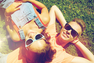 Image showing happy teenage couple lying on grass at summer