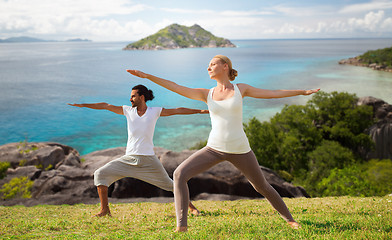 Image showing couple making yoga in warrior pose at seaside