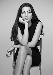 Image showing The colorless portrait of business woman sitting on chair in studio