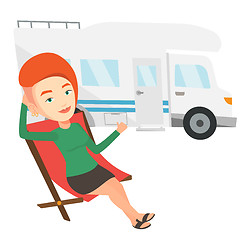 Image showing Woman sitting in chair in front of camper van.