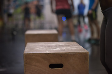 Image showing black woman is performing box jumps at gym