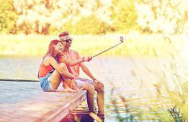 Image showing happy teenage couple taking selfie on smartphone