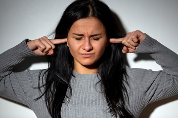 Image showing unhappy woman closing ears by fingers