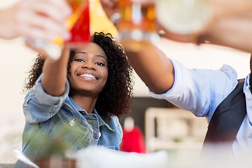 Image showing friends clinking glasses with drinks at restaurant