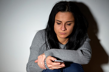 Image showing unhappy crying woman with smartphone