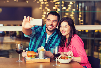 Image showing couple taking selfie by smartphone at restaurant