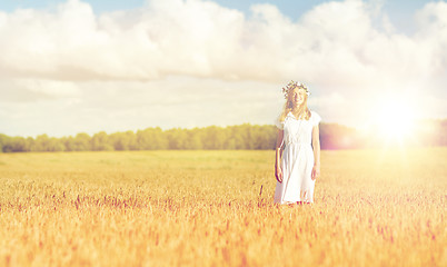 Image showing happy young woman in flower wreath on cereal field