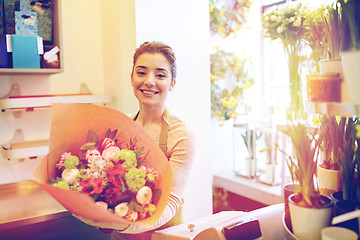 Image showing smiling florist woman with bunch at flower shop