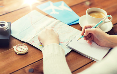 Image showing close up of traveler hands with notepad and pencil