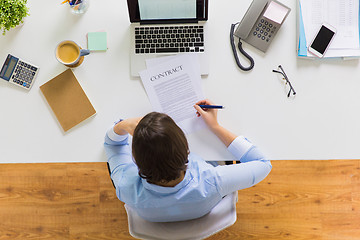 Image showing businesswoman signing contract document at office