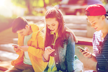 Image showing happy teenage friends with smartphones outdoors