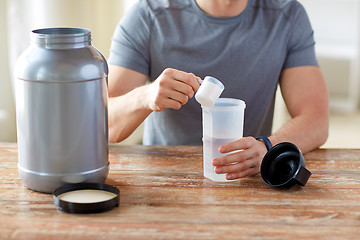 Image showing close up of man with protein shake bottle and jar