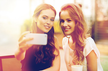 Image showing happy women with smartphone taking selfie at cafe