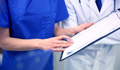 Image showing close up of doctors with clipboard at hospital