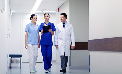 Image showing group of smiling medics at hospital with clipboard