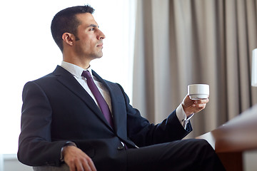 Image showing businessman drinking coffee at hotel room