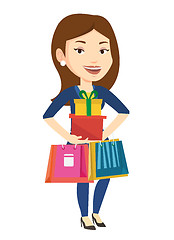 Image showing Happy woman holding shopping bags and gift boxes.