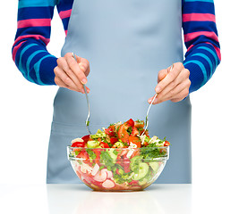 Image showing Cook is mixing salad