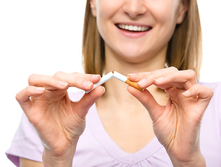 Image showing Young woman is breaking a cigarette