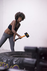 Image showing black woman workout with hammer and tractor tire