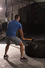 Image showing man workout with hammer and tractor tire