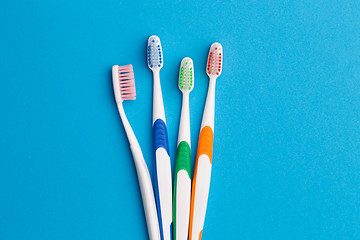 Image showing Photo of four multi-colored toothbrushes