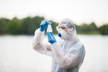 Image showing Biologist holds flask with water