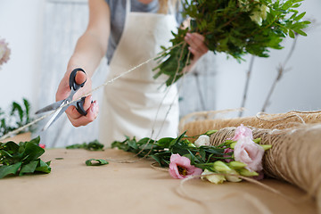 Image showing Florist makes bouquet of flowers