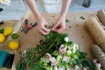 Image showing Florist makes bouquet on table