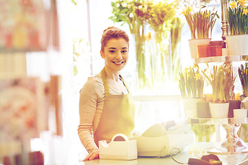 Image showing smiling florist woman at flower shop cashbox