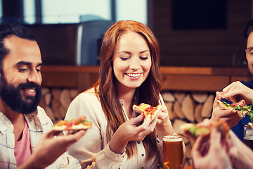 Image showing friends eating pizza with beer at restaurant