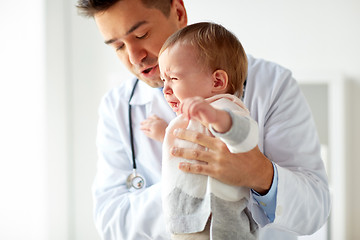 Image showing doctor or pediatrician with crying baby at clinic