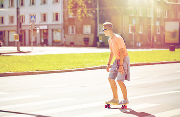 Image showing teenage boy on skateboard crossing city crosswalk