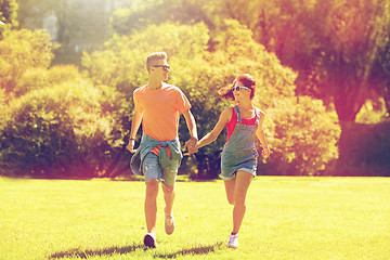 Image showing happy teenage couple running at summer park
