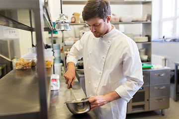 Image showing happy male chef cooking food at restaurant kitchen