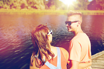 Image showing happy teenage couple sitting on river berth