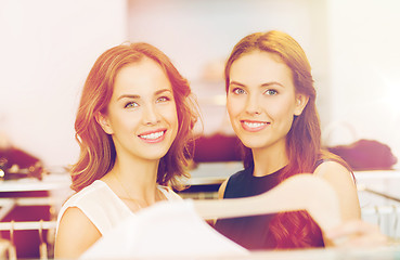 Image showing happy women with shopping bags at clothing shop