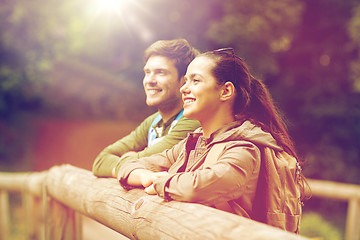 Image showing smiling couple with backpacks on bridge in nature