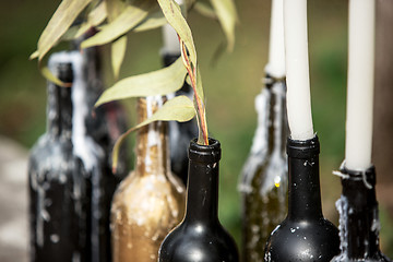 Image showing Burning candle in the vintage black bottle