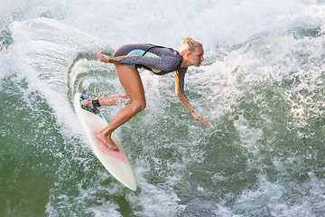 Image showing Atractive sporty girl surfing on famous artificial river wave in Englischer garten, Munich, Germany.