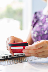 Image showing Woman with laptop and credit card in the cafe.