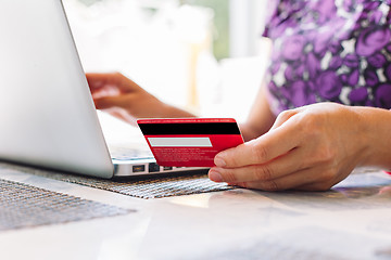 Image showing Woman with laptop and credit card in the cafe.