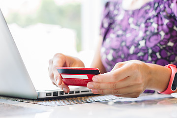 Image showing Woman with laptop and credit card in the cafe.