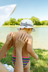 Image showing Parent applying cream on child