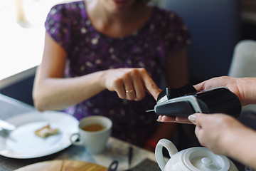 Image showing Woman paying his bill in restaurant