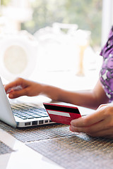 Image showing Woman with laptop and credit card in the cafe.