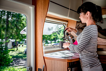 Image showing Woman cooking in camper, motorhome interior